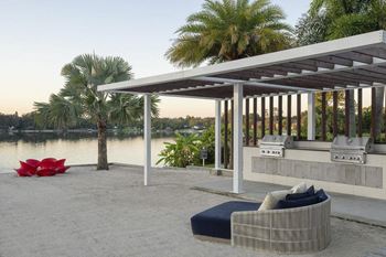 A patio with a couch and a table next to a river